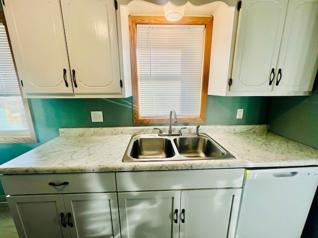 kitchen featuring white cabinetry, dishwasher, and sink