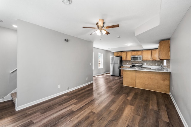 1415 Galtier St, Saint Paul, MN 55117 - kitchen with appliances with stainless steel finishes, brown cabinetry, ceiling fan, baseboards, and decorative backsplash