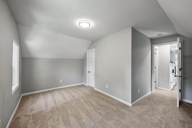 1415 Galtier St, Saint Paul, MN 55117 - bonus room featuring washing machine and clothes dryer, vaulted ceiling, carpet, baseboards, and a textured ceiling