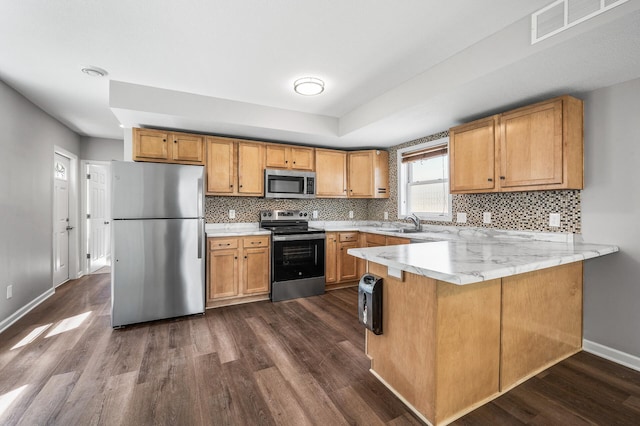 1415 Galtier St, Saint Paul, MN 55117 - kitchen with appliances with stainless steel finishes, dark wood-style flooring, a peninsula, and tasteful backsplash
