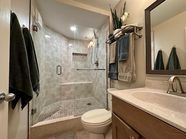 bathroom with tile patterned flooring, vanity, toilet, and a shower with shower door