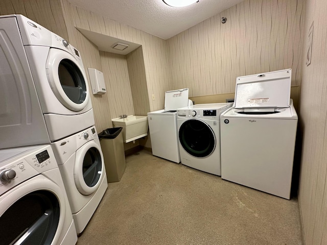 clothes washing area featuring washing machine and dryer, stacked washer / dryer, a textured ceiling, and light carpet