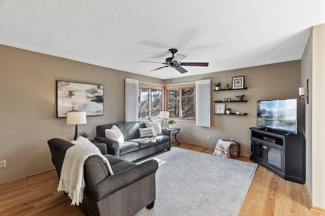 living room with hardwood / wood-style floors, a textured ceiling, and ceiling fan