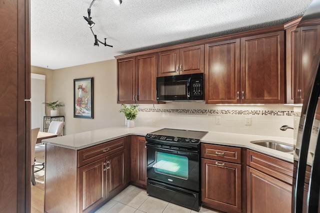 kitchen featuring black appliances, sink, decorative backsplash, light tile patterned floors, and kitchen peninsula