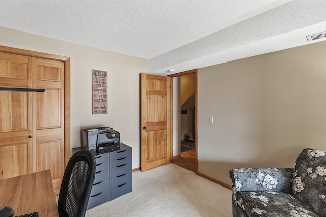 office with light colored carpet and a textured ceiling