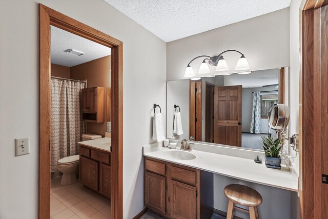 bathroom featuring vanity, tile patterned floors, toilet, and a textured ceiling