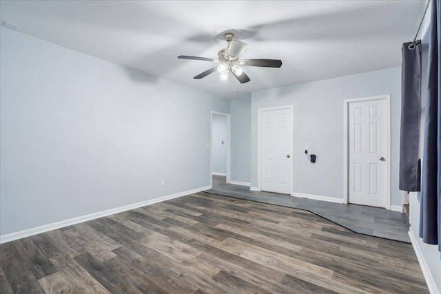 empty room with ceiling fan and dark hardwood / wood-style flooring