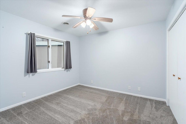 empty room with ceiling fan and carpet floors