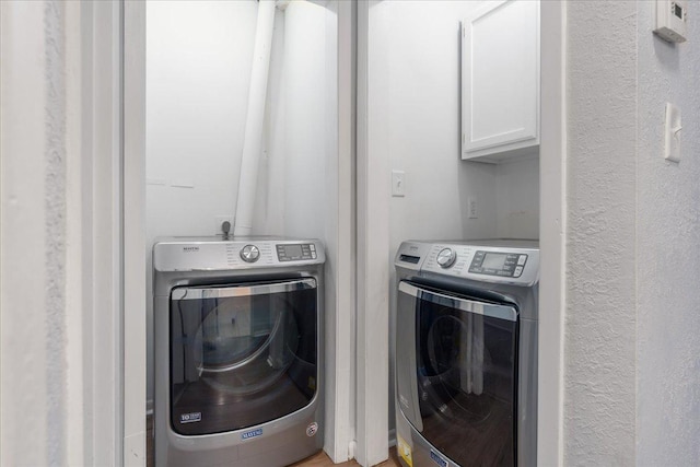 washroom featuring washer and dryer and cabinets