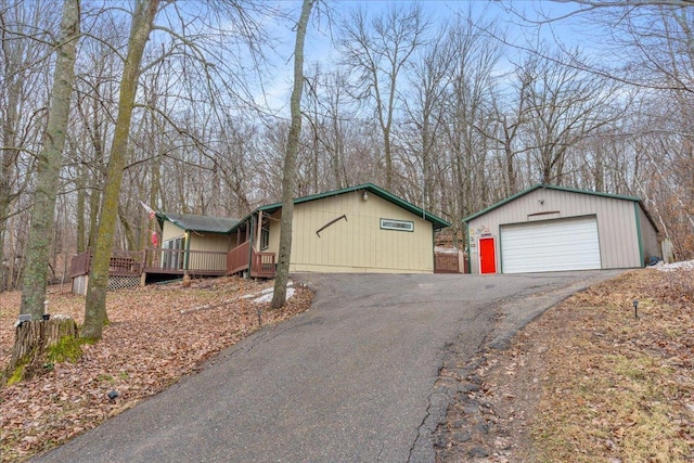 view of front of property featuring a wooden deck, an outdoor structure, and a garage