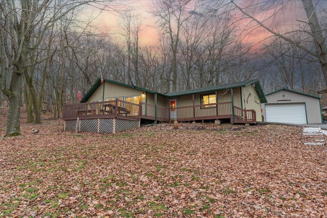 view of front facade featuring an outbuilding, a garage, and a deck