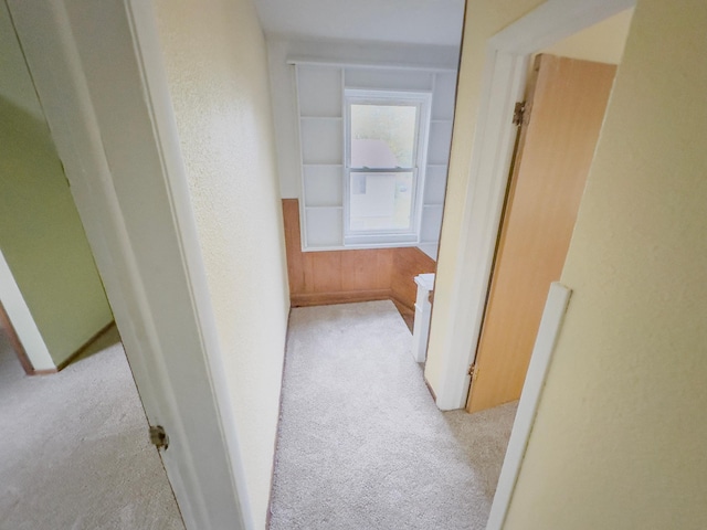 hallway featuring light colored carpet