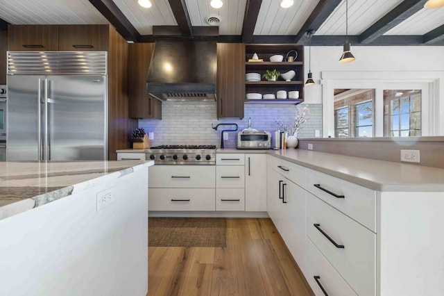 kitchen with white cabinets, appliances with stainless steel finishes, custom exhaust hood, beamed ceiling, and backsplash