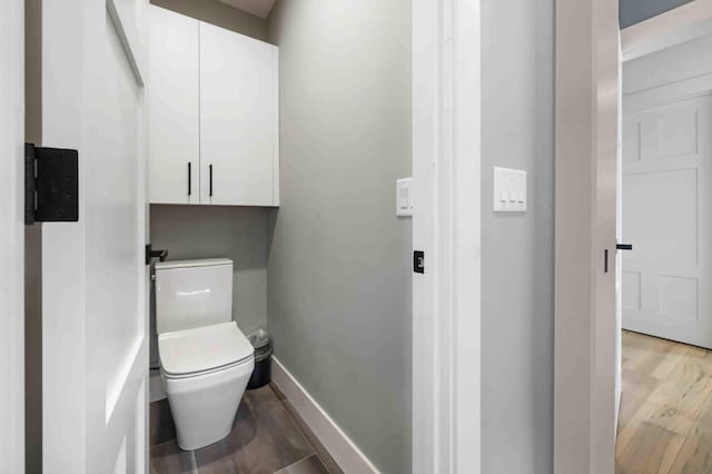 bathroom with toilet and hardwood / wood-style flooring