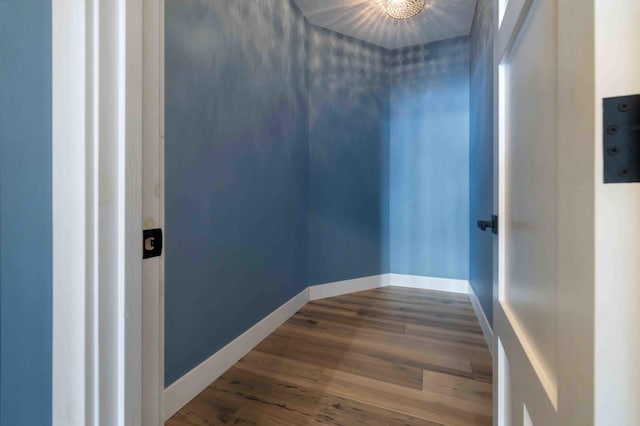 hallway with a textured ceiling, a chandelier, and hardwood / wood-style flooring