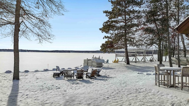 yard layered in snow featuring a water view