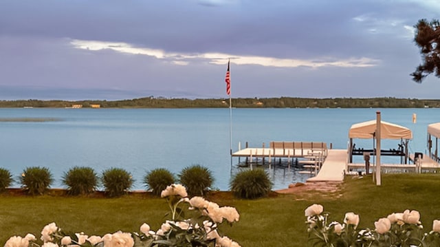 dock area with a yard and a water view