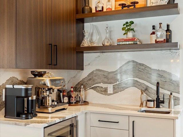 kitchen with white cabinets, decorative backsplash, sink, and beverage cooler