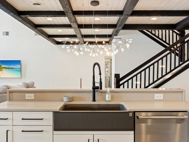 kitchen featuring white cabinetry, beam ceiling, stainless steel dishwasher, and coffered ceiling