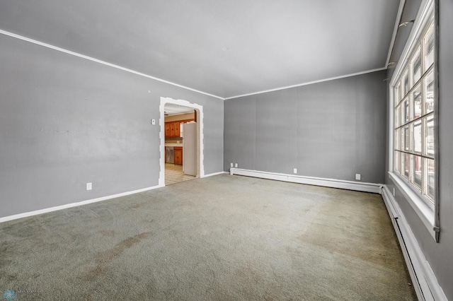 empty room with baseboard heating, crown molding, and carpet flooring