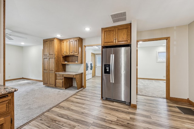 kitchen with ceiling fan, light hardwood / wood-style floors, independent washer and dryer, and stainless steel refrigerator with ice dispenser