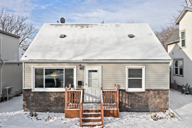 snow covered back of property featuring ac unit