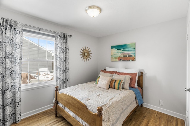 bedroom with baseboards and wood finished floors