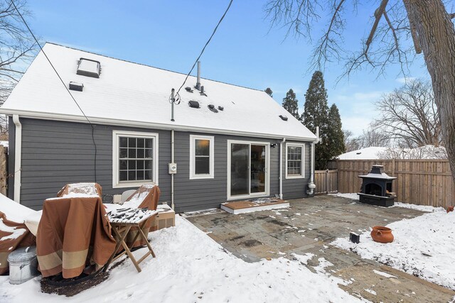 snow covered house with fence