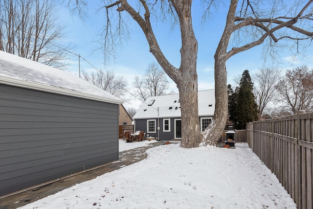 snow covered back of property with fence