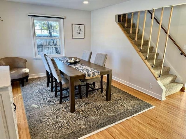 dining area with stairway, wood finished floors, and baseboards