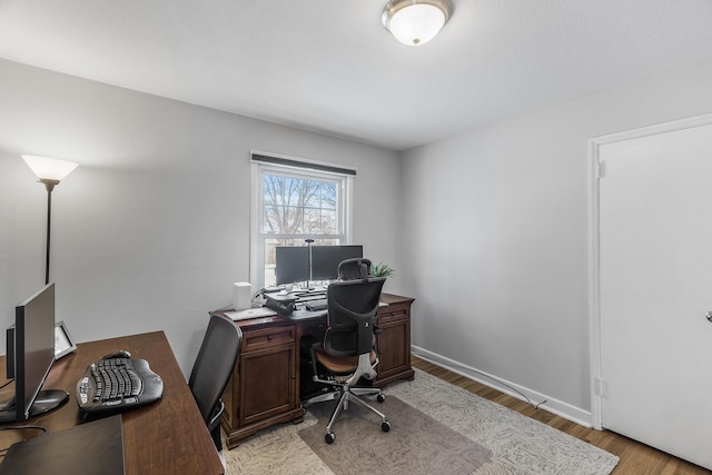 office space featuring light wood-type flooring and baseboards