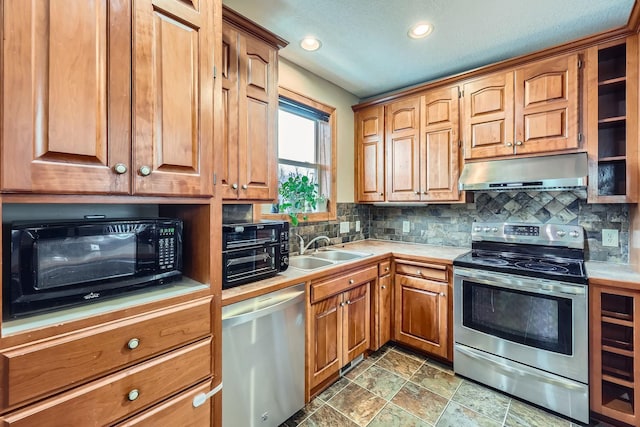 kitchen featuring appliances with stainless steel finishes, tasteful backsplash, a textured ceiling, sink, and tile countertops