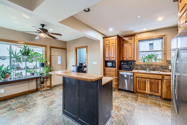 kitchen featuring a center island, a healthy amount of sunlight, sink, and appliances with stainless steel finishes