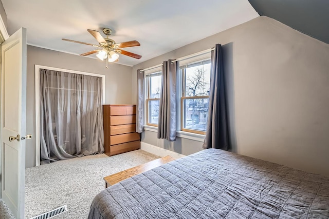 carpeted bedroom with ceiling fan and vaulted ceiling