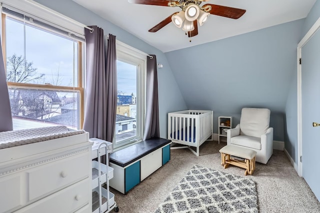 bedroom featuring a crib, carpet floors, vaulted ceiling, and ceiling fan