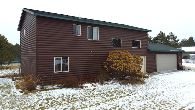 snow covered property featuring a garage