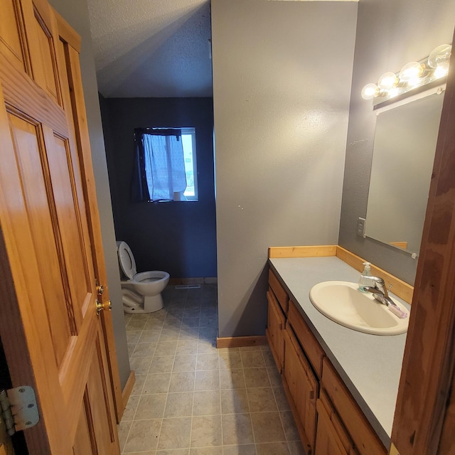 bathroom featuring vanity, toilet, and a textured ceiling