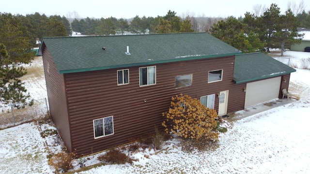 view of snowy exterior featuring a garage