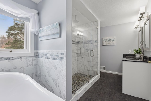 bathroom with walk in shower, vanity, and a textured ceiling