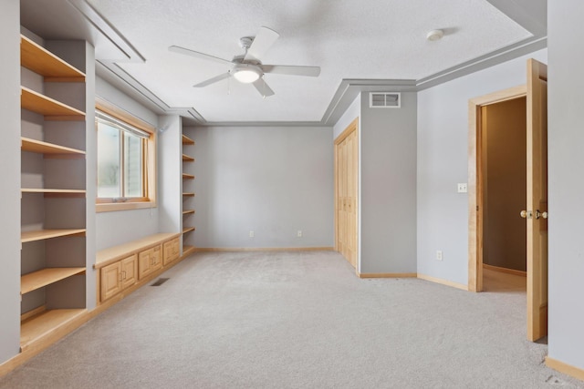 unfurnished bedroom featuring ceiling fan, light colored carpet, and a textured ceiling