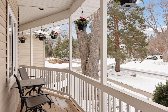 snow covered deck with covered porch