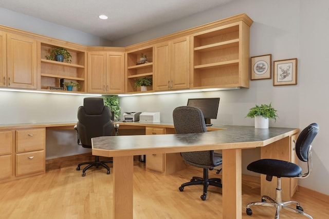 office with built in desk and light hardwood / wood-style flooring