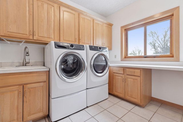 laundry room featuring cabinets, sink, washing machine and dryer, and light tile patterned floors