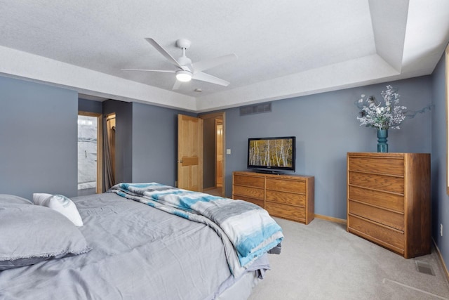 bedroom with ceiling fan, light carpet, and a textured ceiling