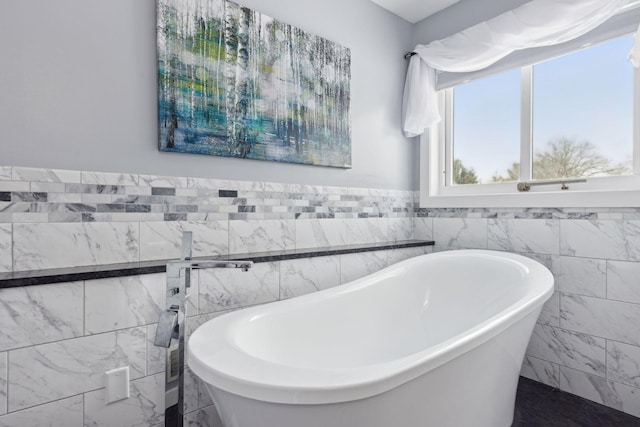 bathroom with tile walls and a bathtub