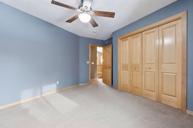 unfurnished bedroom with light carpet, ceiling fan, and a closet