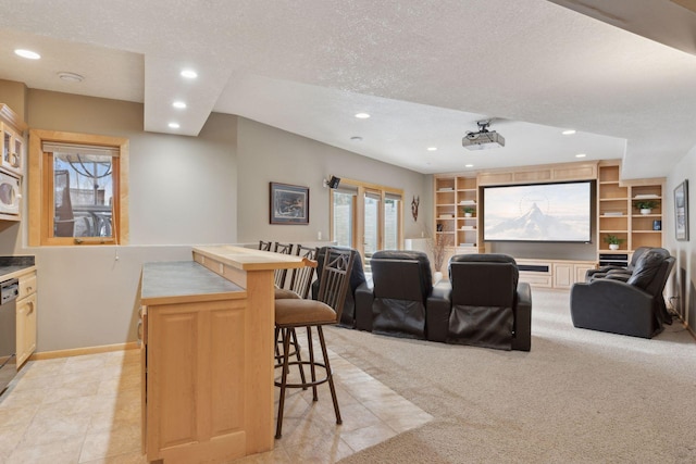 carpeted cinema room featuring built in features and a textured ceiling