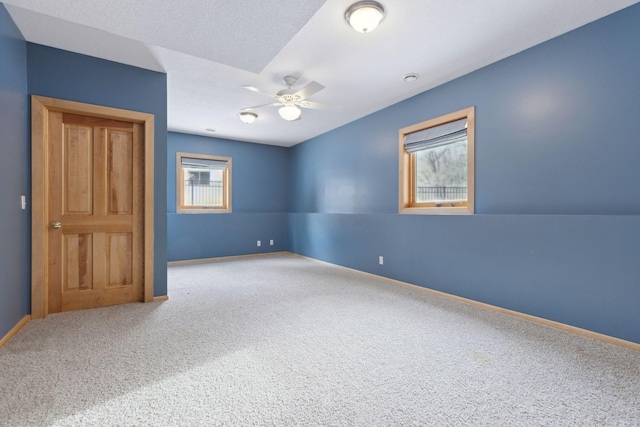 unfurnished room featuring ceiling fan and carpet flooring