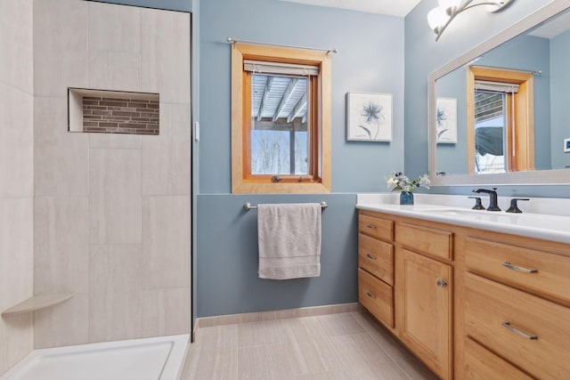 bathroom with tile patterned flooring, vanity, and walk in shower