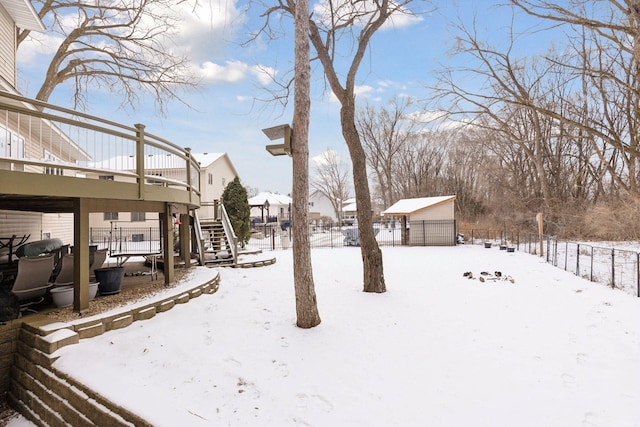 snowy yard featuring a storage shed